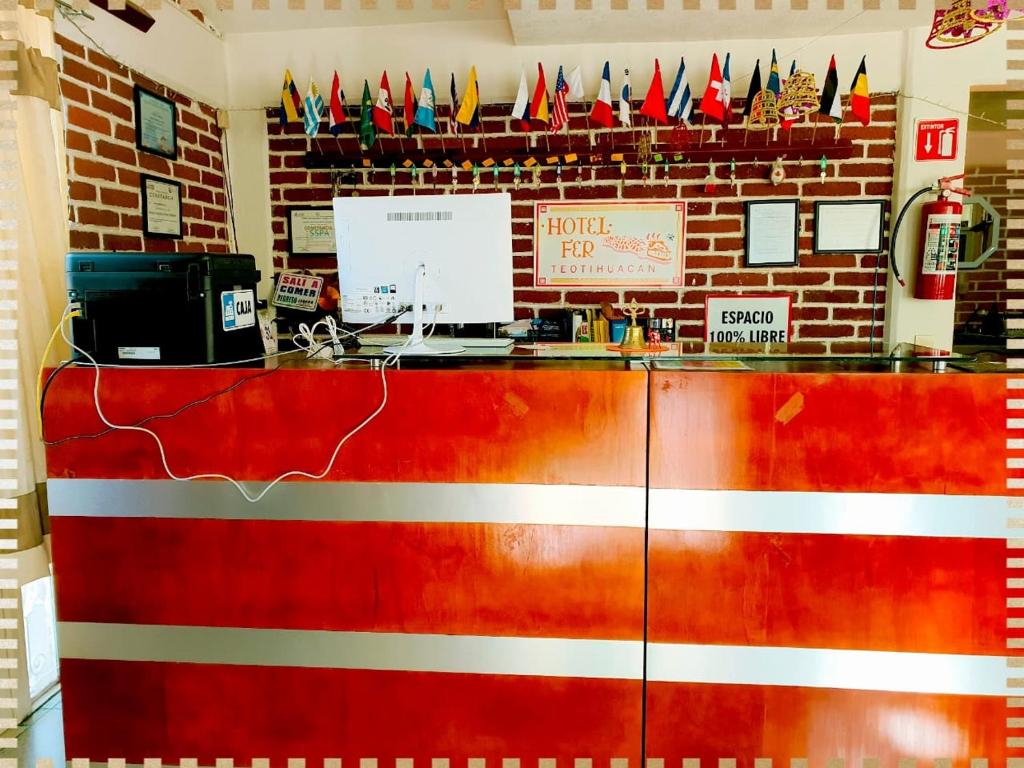 a red counter in a restaurant with flags on the wall at Hotel Fer in San Juan Teotihuacán