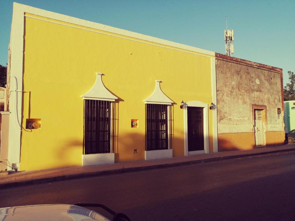 żółty budynek z czterema oknami na ulicy w obiekcie Casa Mama Bety w mieście Valladolid