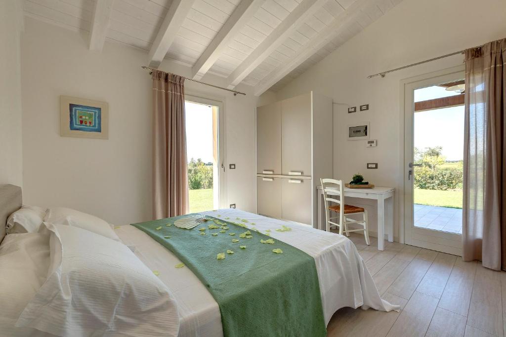 Agriturismo Il Lentisco في بولغيري: غرفة نوم بسرير مع طاولة ونافذة
