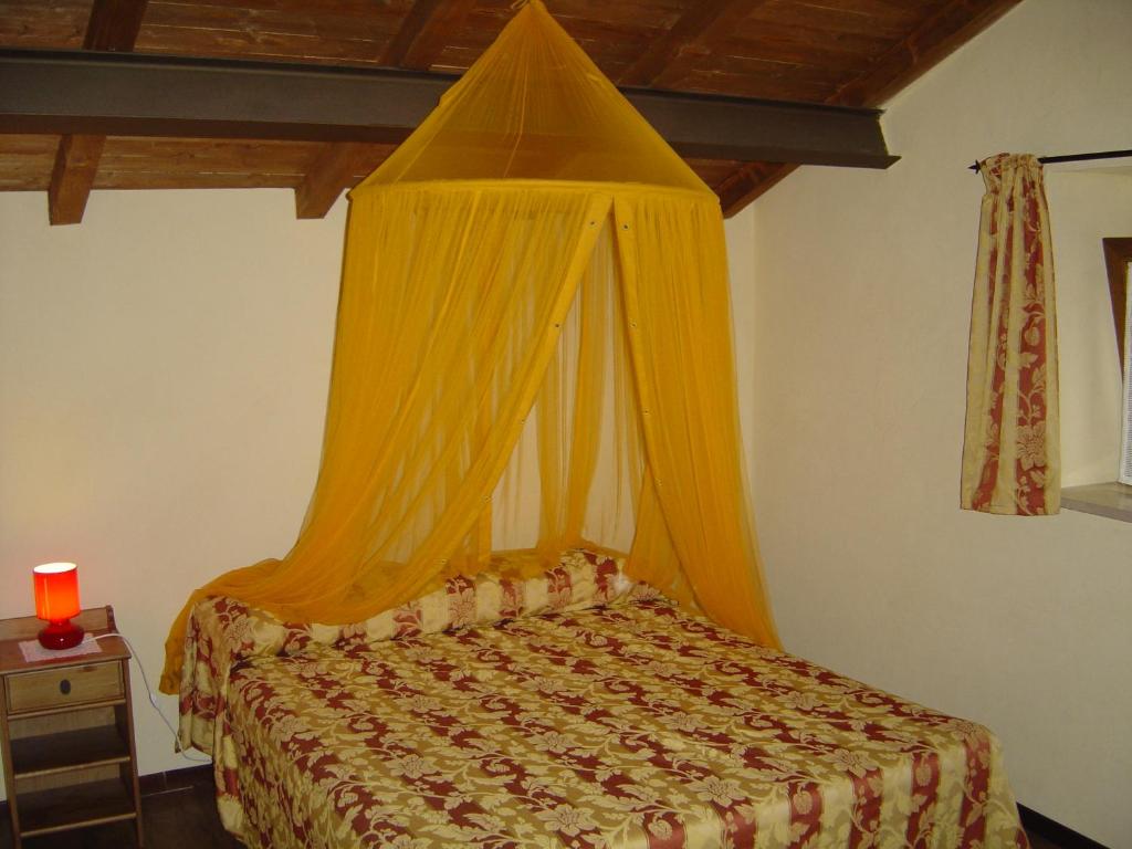 a bedroom with a bed with a yellow canopy at Dimora Antico Forno Soprano in Maschito