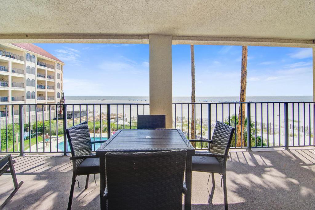 a balcony with a table and chairs and a view of the ocean at Seascape 218 in Isle of Palms