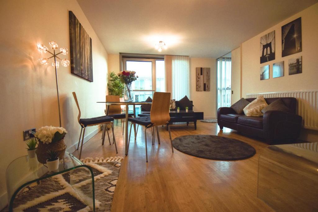 ein Wohnzimmer mit Sofa und Tisch in der Unterkunft The Hub - Spacious, bright and modern with free parking in Milton Keynes