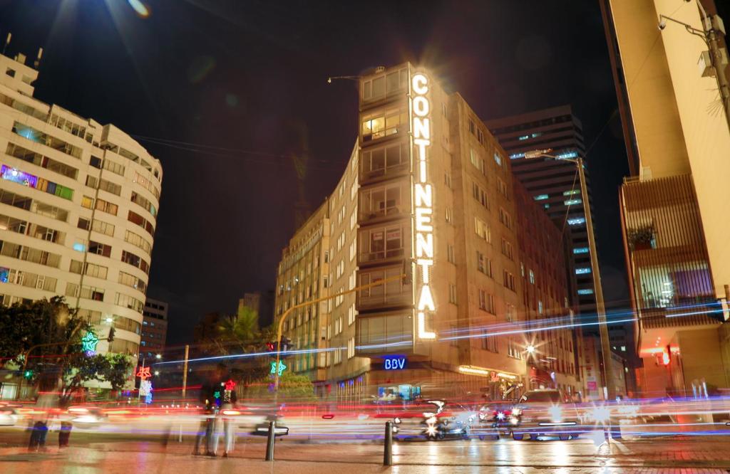 a tall building with a clock tower at night at Hotel Aparta Suite Continental Bogotá in Bogotá