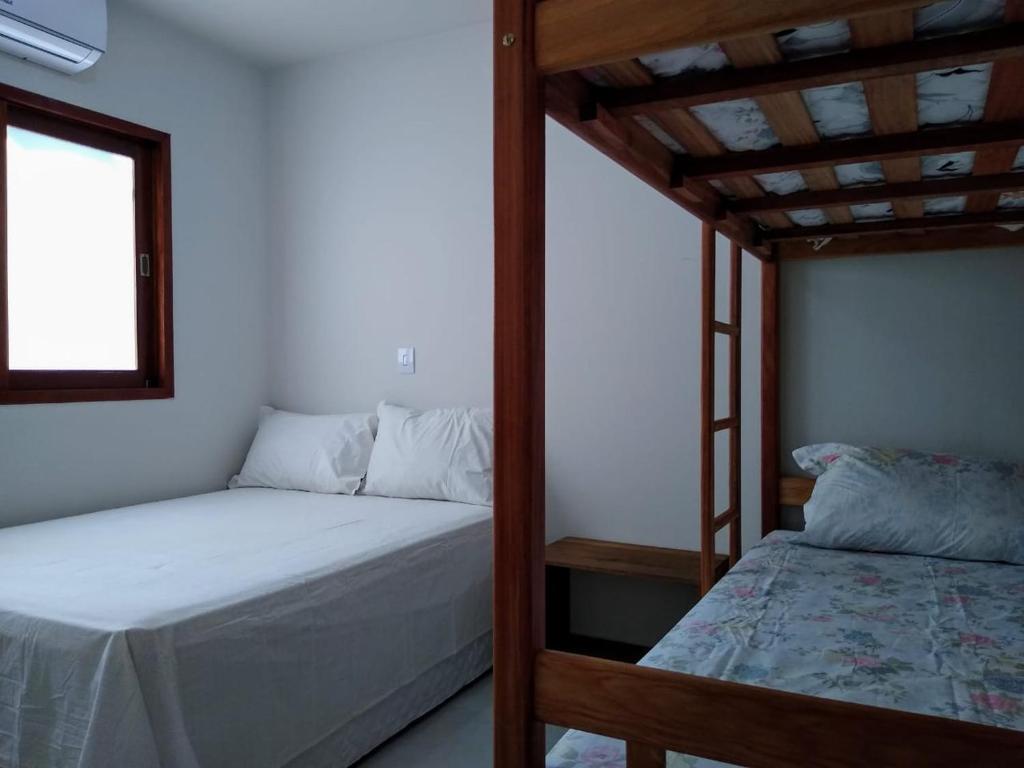 a bedroom with two bunk beds and a window at GREEN HOUSE in Pipa