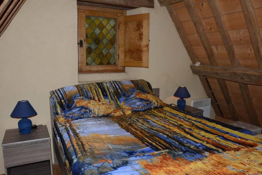 a bed in a bedroom with two lamps and a window at Gîte 3 pers Jacuzzi extérieur sous bulle, possibilité table d&#39;hôtes le soir in Tréduder