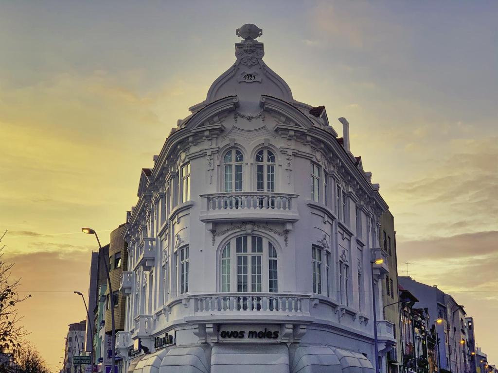 un edificio bianco con sopra un orologio di Guesthouse Tricana de Aveiro ad Aveiro