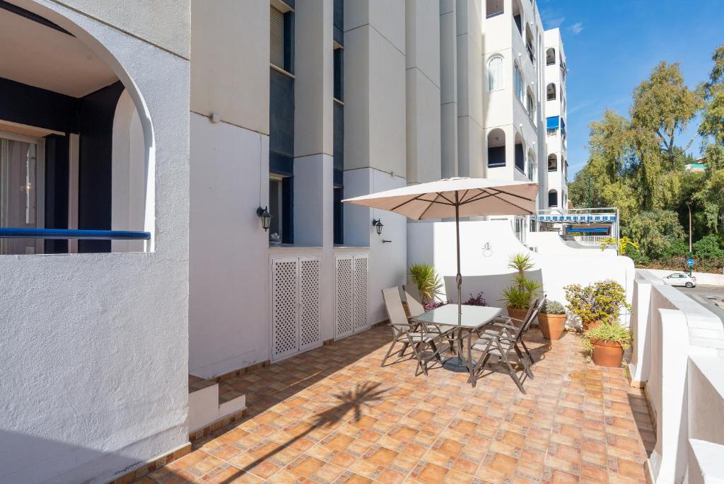 patio ze stołem, krzesłami i parasolem w obiekcie Virginia Beach & private terrace by ELE Apartments w Maladze