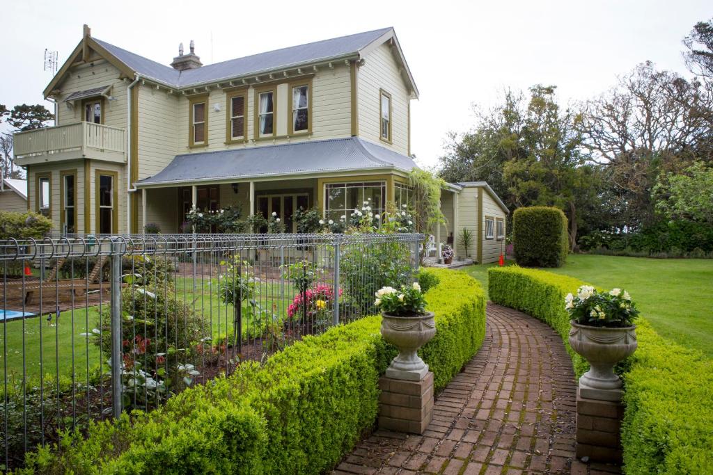 een huis met een stenen loopbrug voor een tuin bij Tairoa Lodge in Hawera