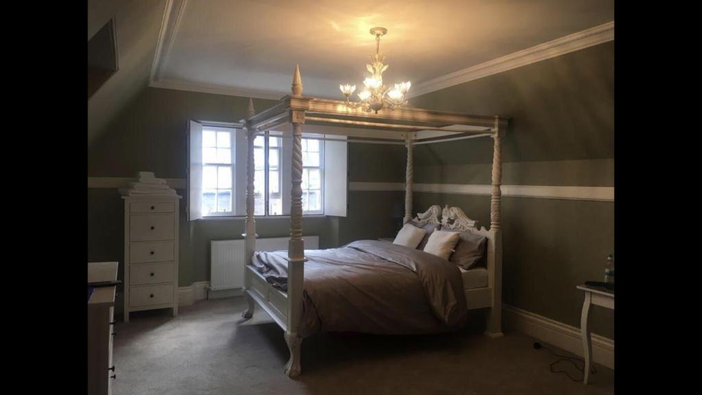 a bedroom with a canopy bed and a window at Dundee Beds in Dundee