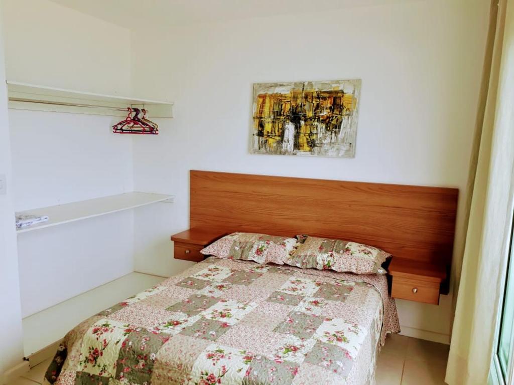 um quarto com uma cama com uma cabeceira de madeira em Casa NA PRAIA do Peró em Cabo Frio
