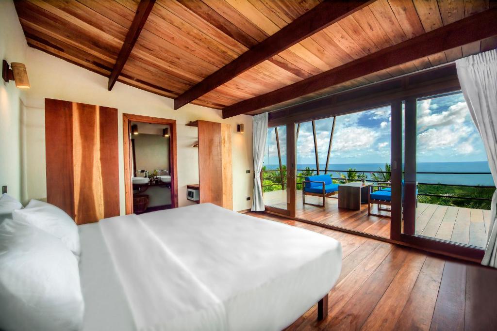 a hotel room with a bed, table and window at Ecotao Lodge in Ko Tao