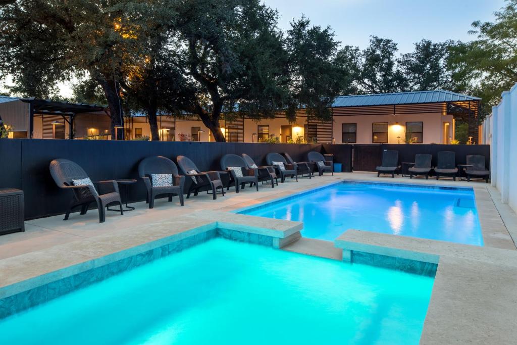 a swimming pool with chairs at Hotel Flora and Fauna in Wimberley