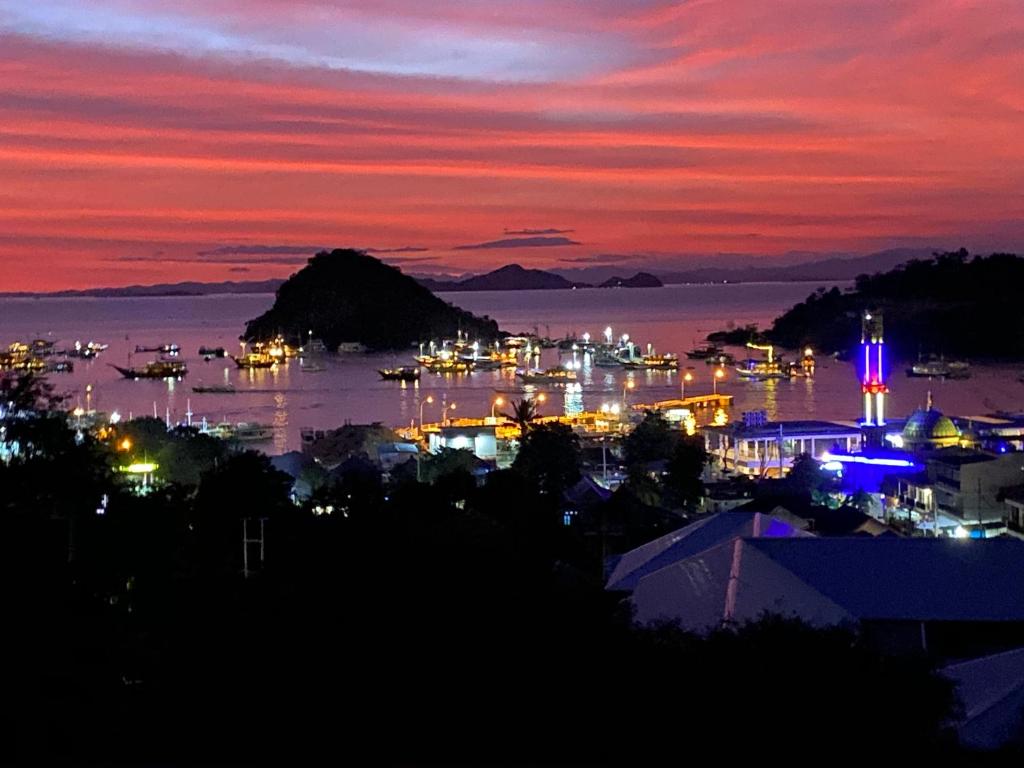 a night view of a harbor with boats in the water at Pesona Room and restaurant in Labuan Bajo