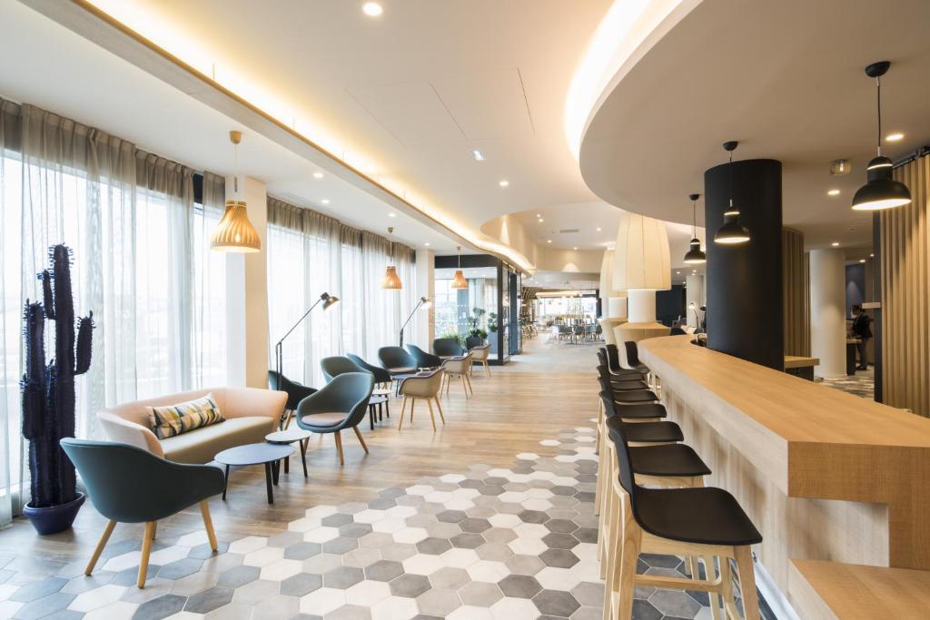 a lobby with a line of chairs and a bar at Holiday Inn Express - Paris - CDG Airport by IHG in Roissy-en-France