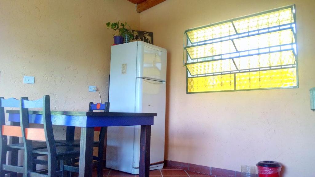 eine Küche mit einem Tisch und einem weißen Kühlschrank in der Unterkunft Dimensión moonlight in La Falda