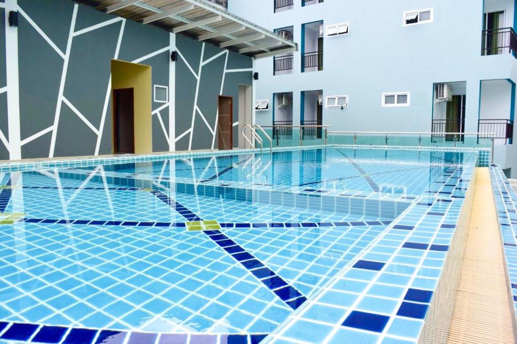 a swimming pool in front of a building at Morakot Twin Chumphon in Chumphon