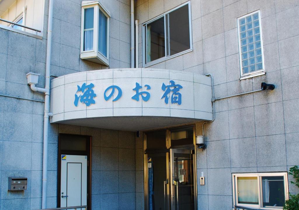 a building with chinese writing on the front of it at 海のお宿 in Susami
