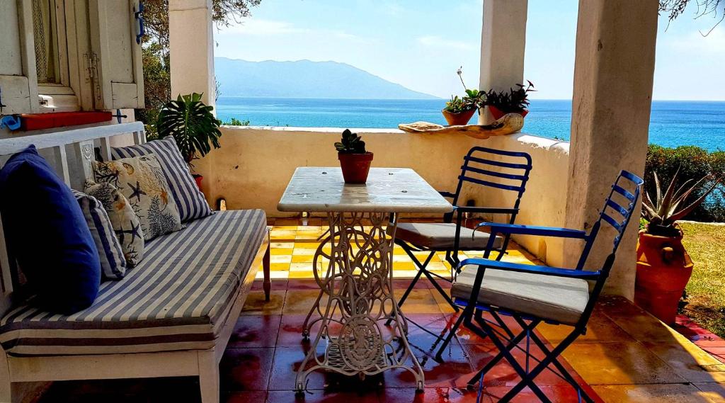 un patio con mesa, sillas y el océano en Loukoulos' maisonette, en Marathokampos