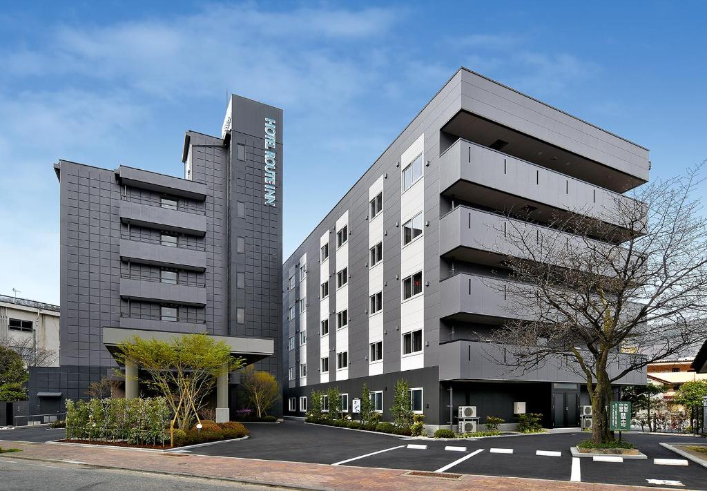 an office building in front of a parking lot at HOTEL ROUTE-INN Kamiyamada Onsen in Chikuma