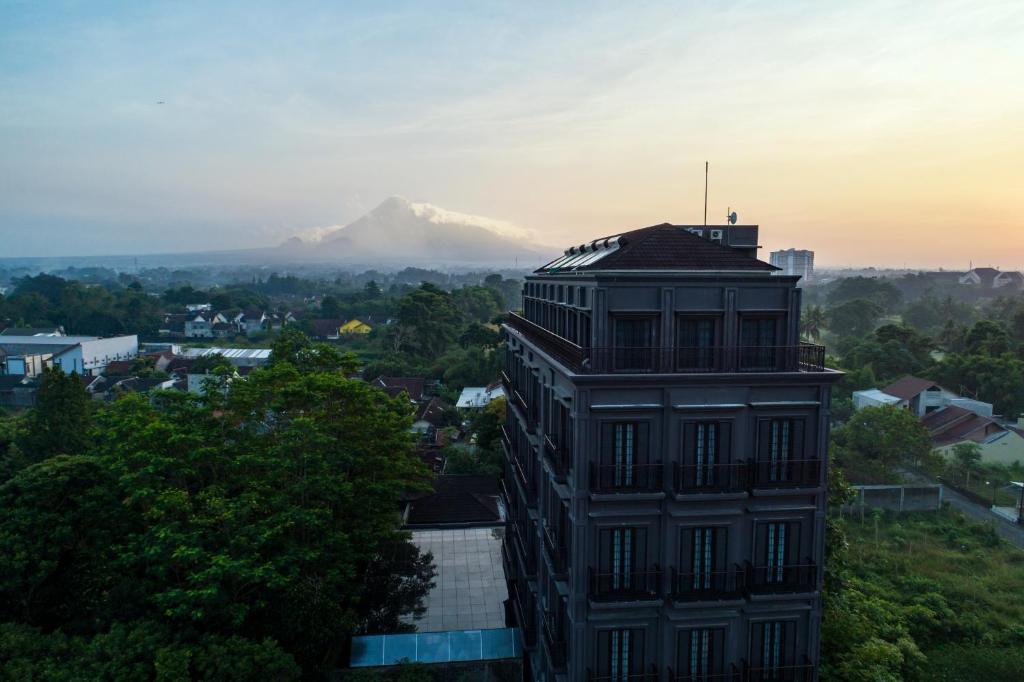a building with a mountain in the background at Sofia Boutique Residence in Yogyakarta