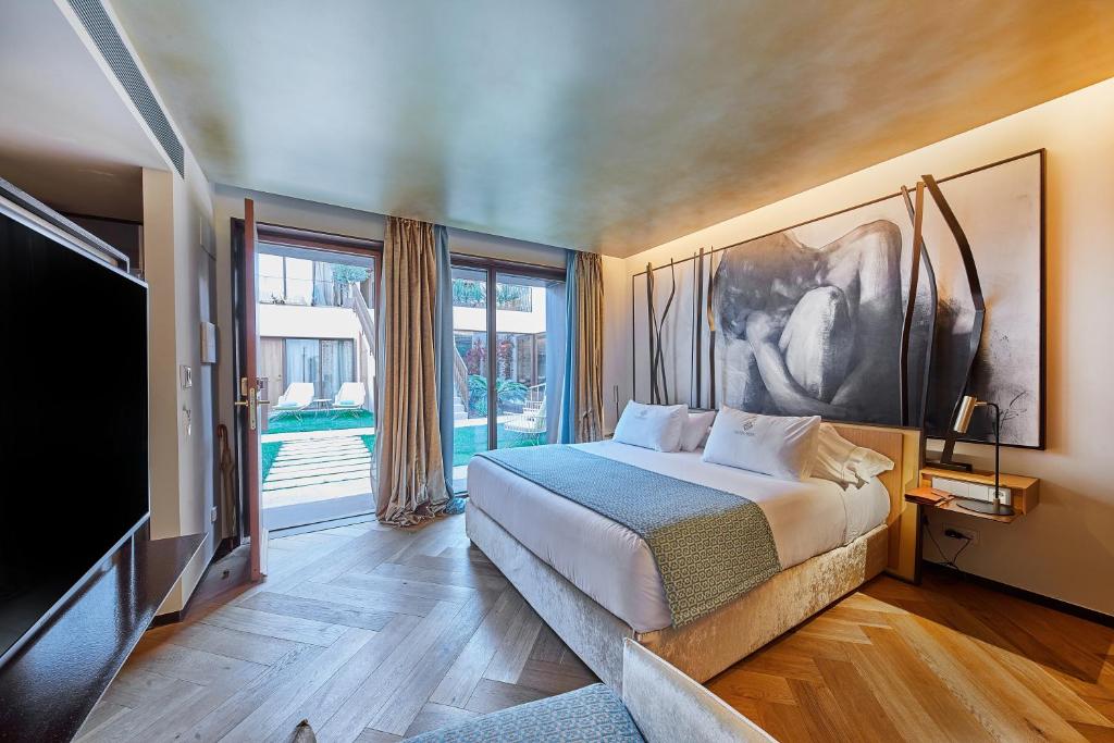 een slaapkamer met een groot bed en een televisie bij Sa Creu Nova Petit Palais Art & Spa in Campos