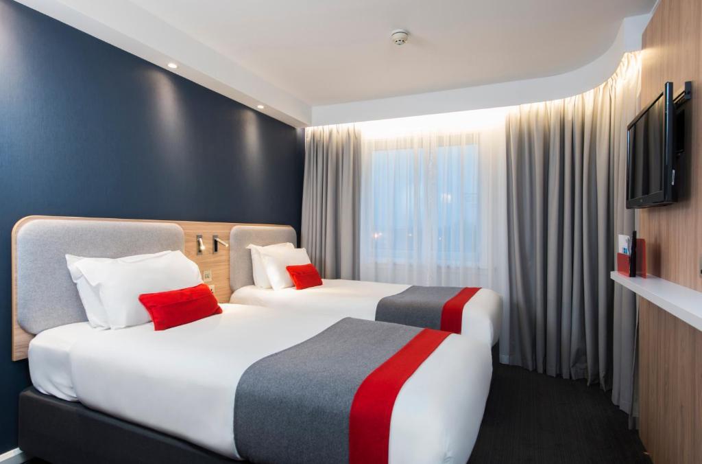 a hotel room with two beds and a television at Holiday Inn Express Edinburgh - Leith Waterfront by IHG in Edinburgh