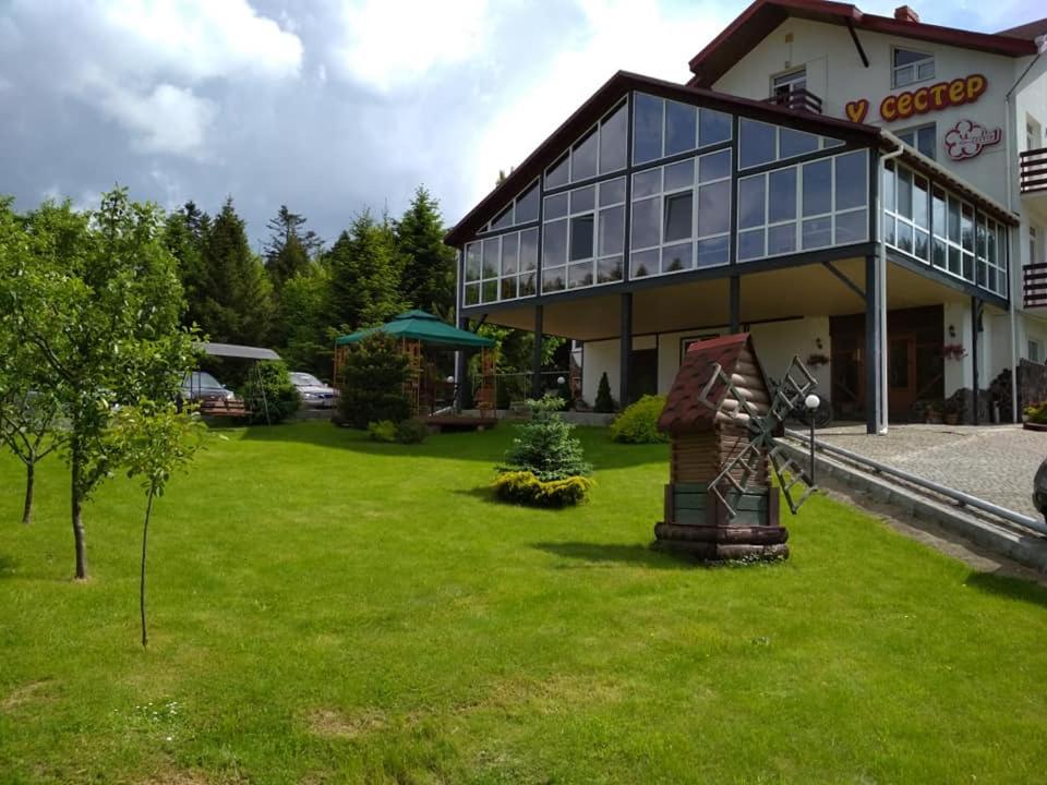 un grand bâtiment avec une pelouse devant lui dans l'établissement Guest House U Sester, à Skhidnitsa