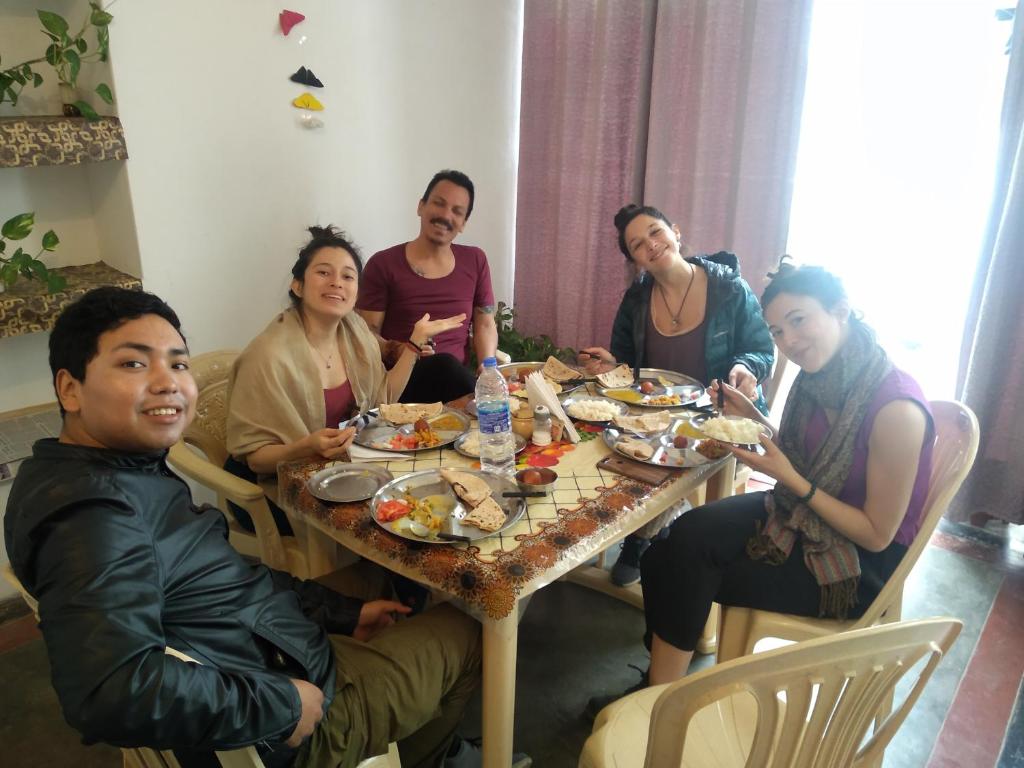 a group of people sitting around a table eating food at Namaste Homestay in Khajurāho
