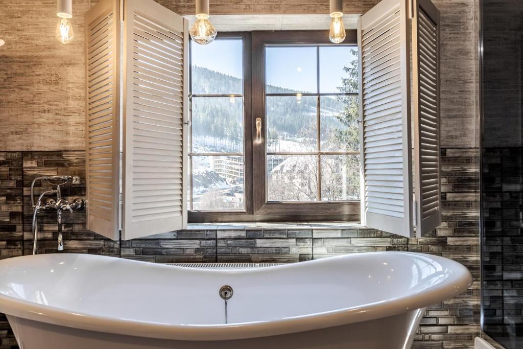 a bath tub in a bathroom with a window at Маєток "ZYMON & SKI" in Bukovel