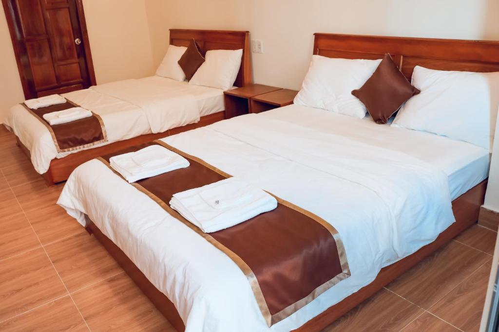 twee bedden in een hotelkamer met handdoeken erop bij Khách sạn Trường Long in Phan Rang