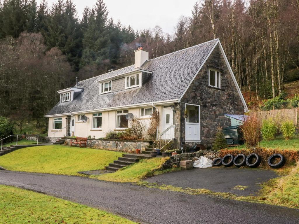 a large white house with a yard at Glenfinglas Dam Cottage in Callander