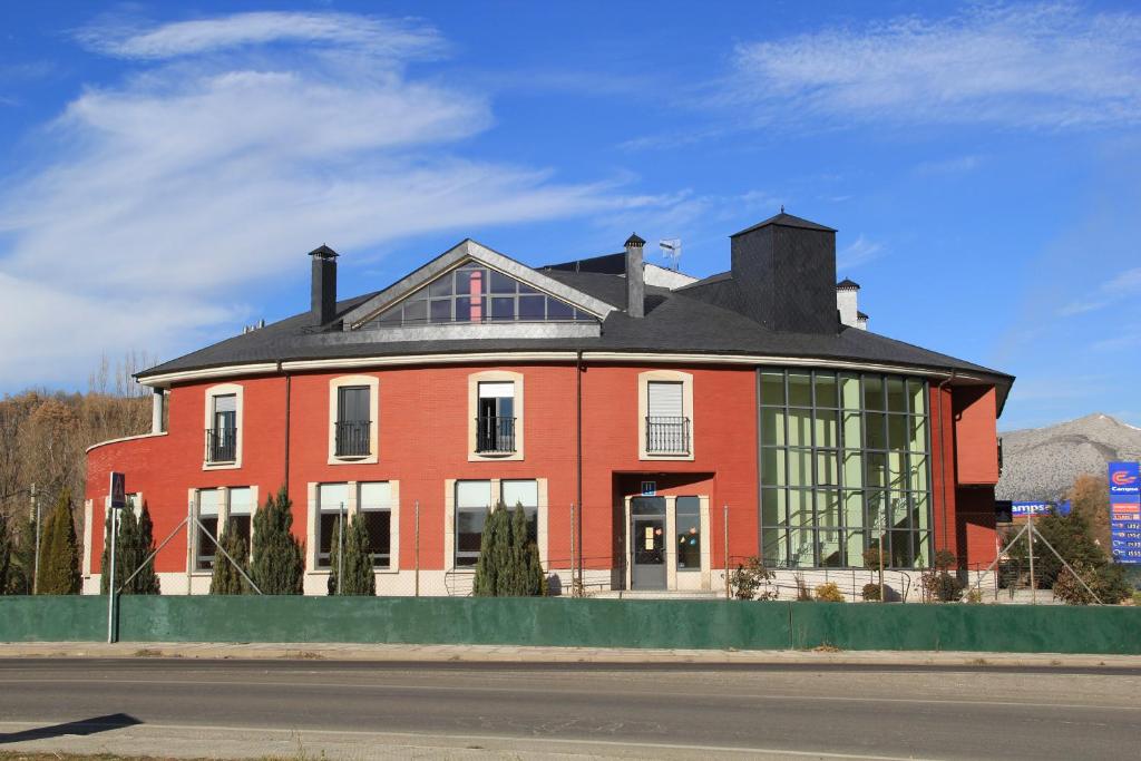 una gran casa de ladrillo rojo con techo negro en Hotel Tremazal en Guardo