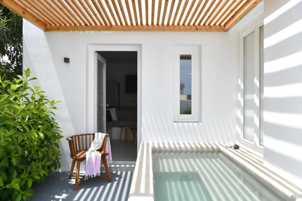 a house with a swimming pool and a wooden roof at Thiro Santorini in Fira