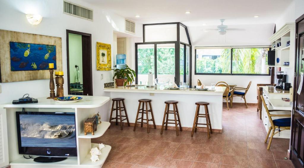 a kitchen and living room with a bar with stools at Royal Palms 6 condo in Playa del Carmen