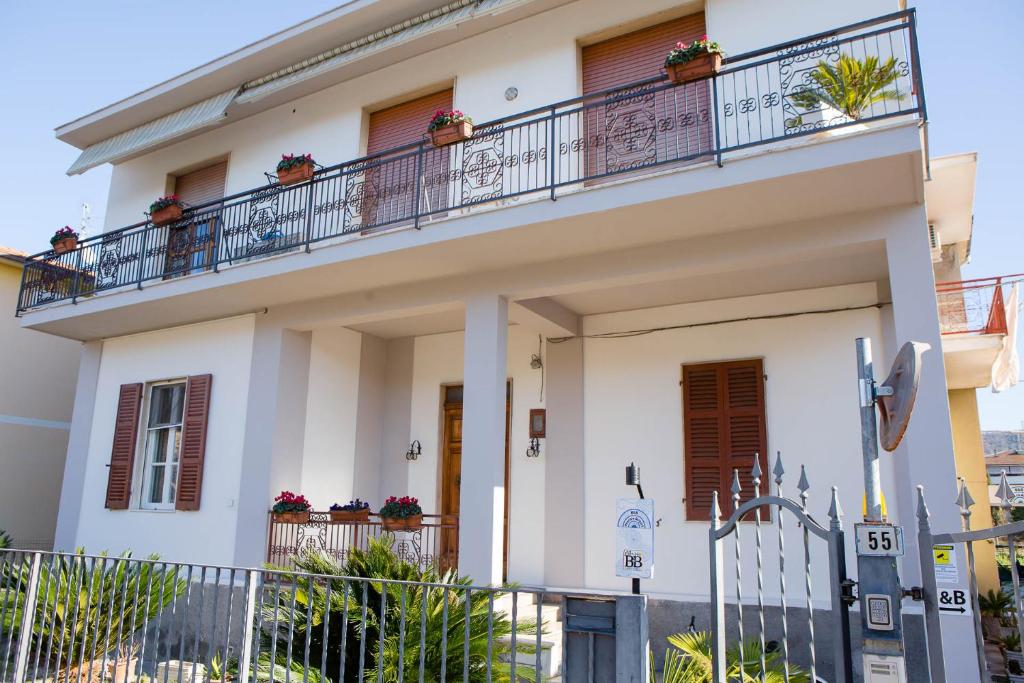 a white house with potted plants on the balcony at B&B Pescara Airport in San Giovanni Teatino