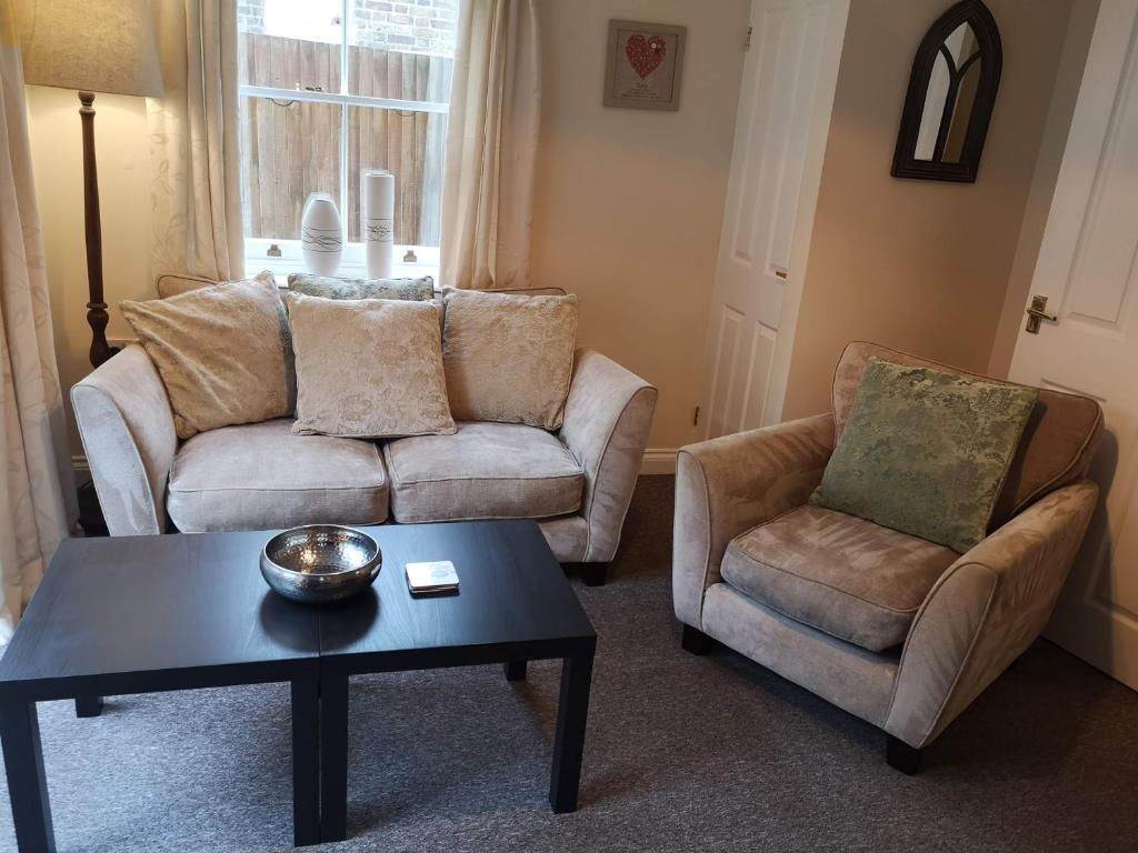 a living room with a couch and a chair and a table at Coastal Escape Deal - 2 Bedroom House at Kent Escapes Short Lets & Serviced Accommodation Kent, Wifi in Deal