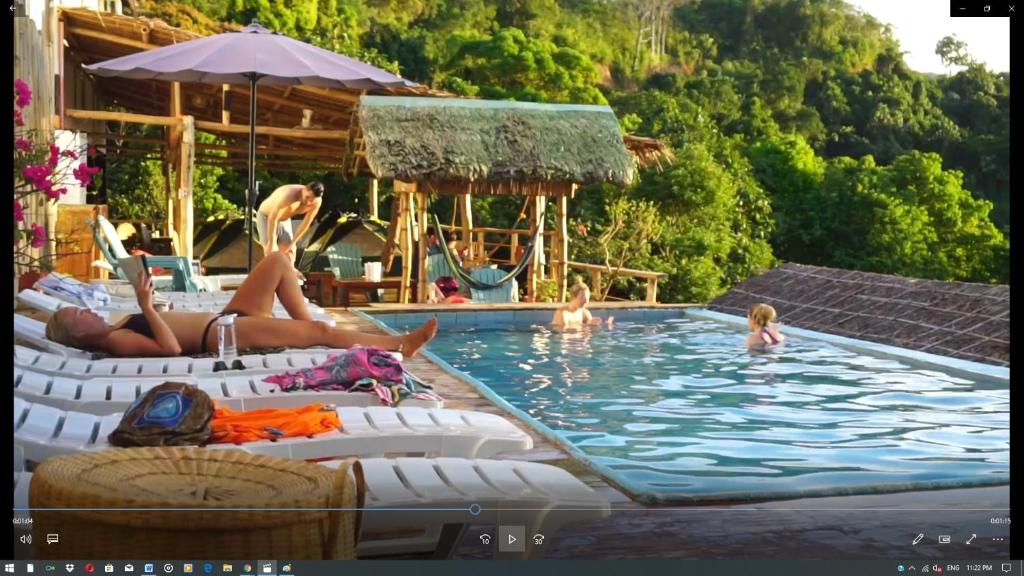 a group of people laying in a swimming pool at Lexias Hostel and Workspace - El Nido in El Nido