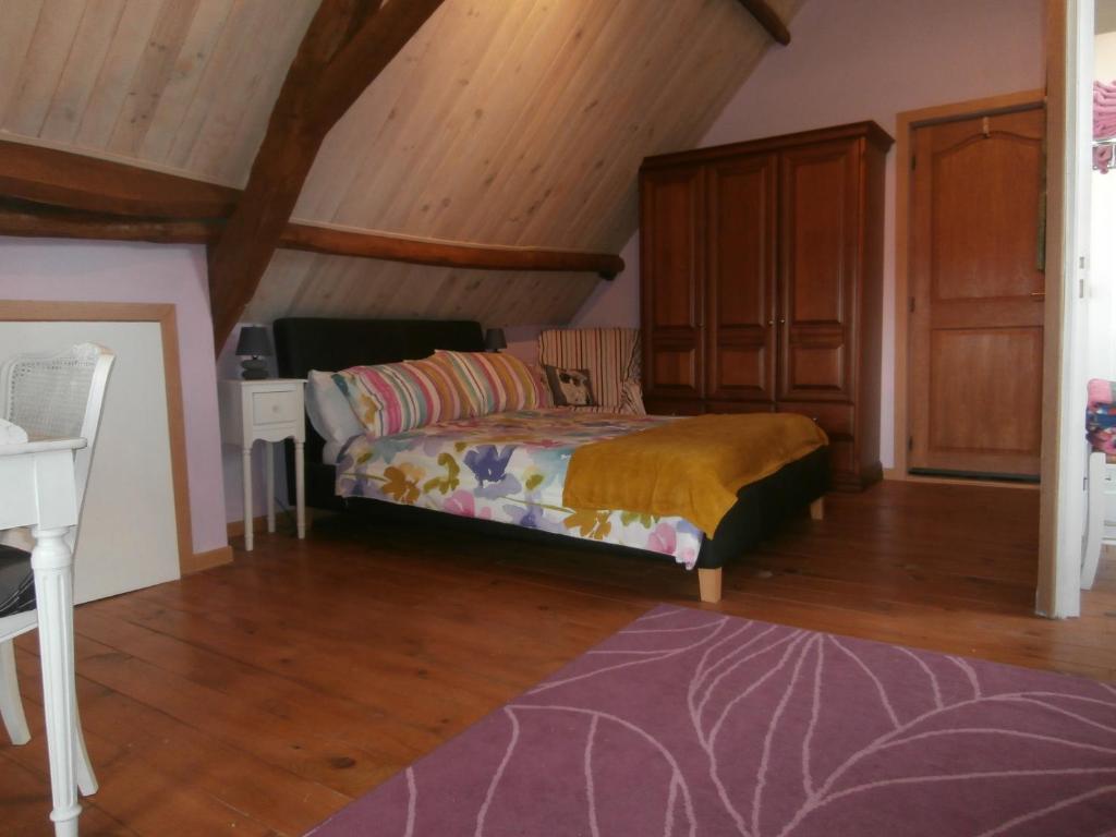 een slaapkamer met een bed in een kamer met houten plafonds bij Les Tachats in Hautefort