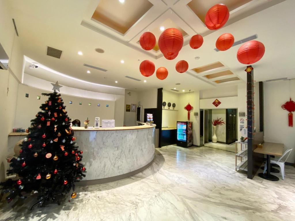 un árbol de Navidad en un vestíbulo con linternas rojas en The Rivero Hotel, en Kaohsiung