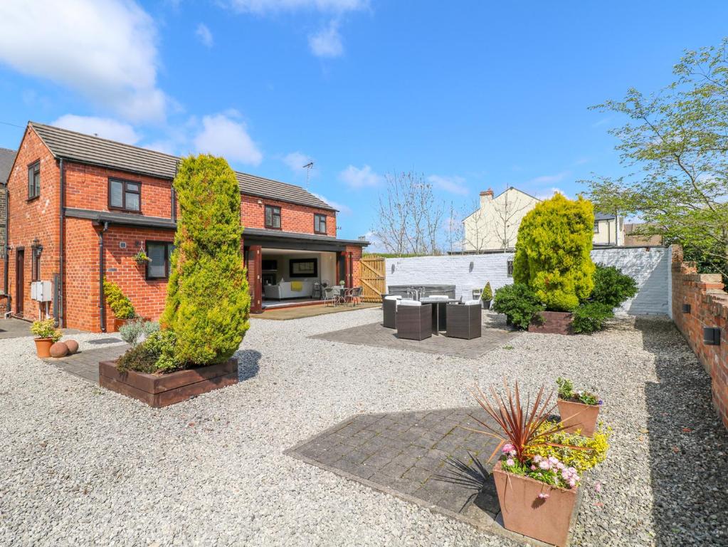 una casa de ladrillo con un patio con plantas en Netherfield Cottage en Chesterfield