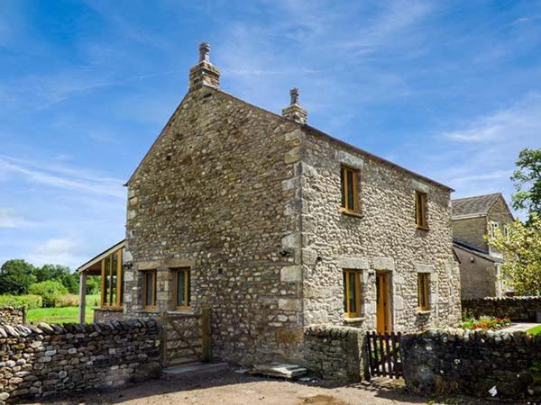an old stone house with a stone wall at Lane Foot Cottage in Lancaster