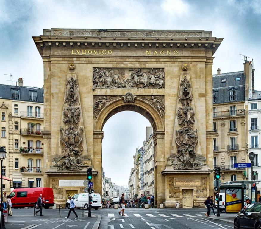 an arch in a city with people crossing a street at 52 - Urban Collection Grands Boulevards in Paris