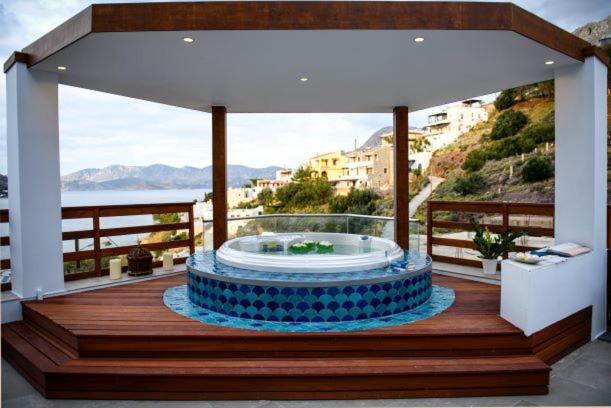 a hot tub on a deck with a view of the ocean at Vasilis Studios in Myrties