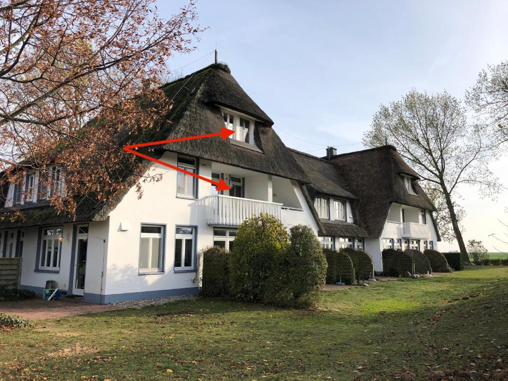 Cette grande maison blanche est dotée d'un toit de chaume. dans l'établissement Refugium Raabenhorst im Landhaus am Haff, à Stolpe auf Usedom