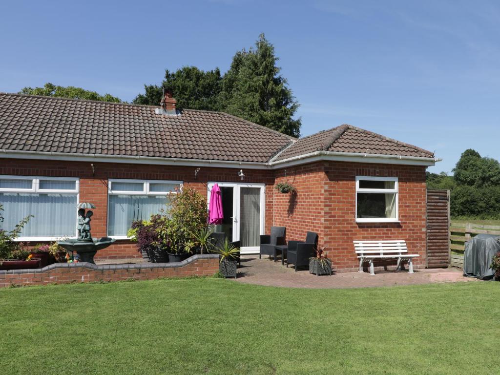 a brick house with a bench in the yard at The Bungalow in York