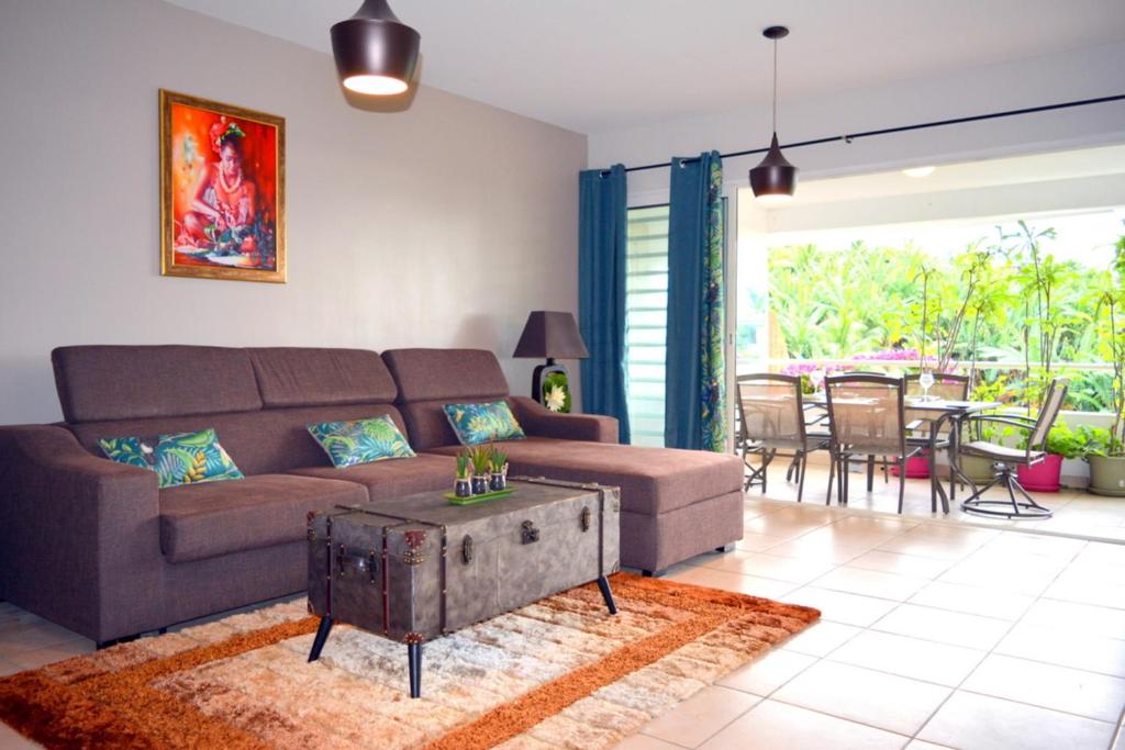 - un salon avec un canapé et une table dans l'établissement Kai cosy apartment with terrace pool and sea view near Papeete, à Fa'a'ā
