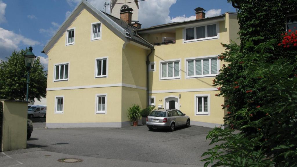 a yellow house with a car parked in front of it at Haus Pleterski in Obervellach
