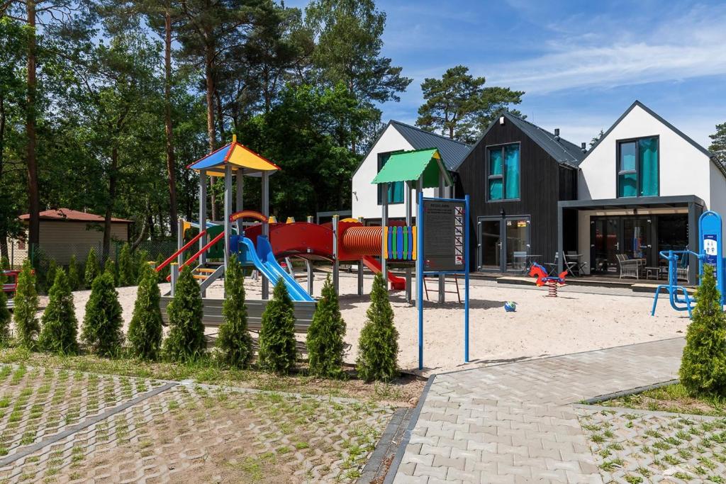 a playground in front of a building at Villa6 I Domki Pobierowo in Pobierowo