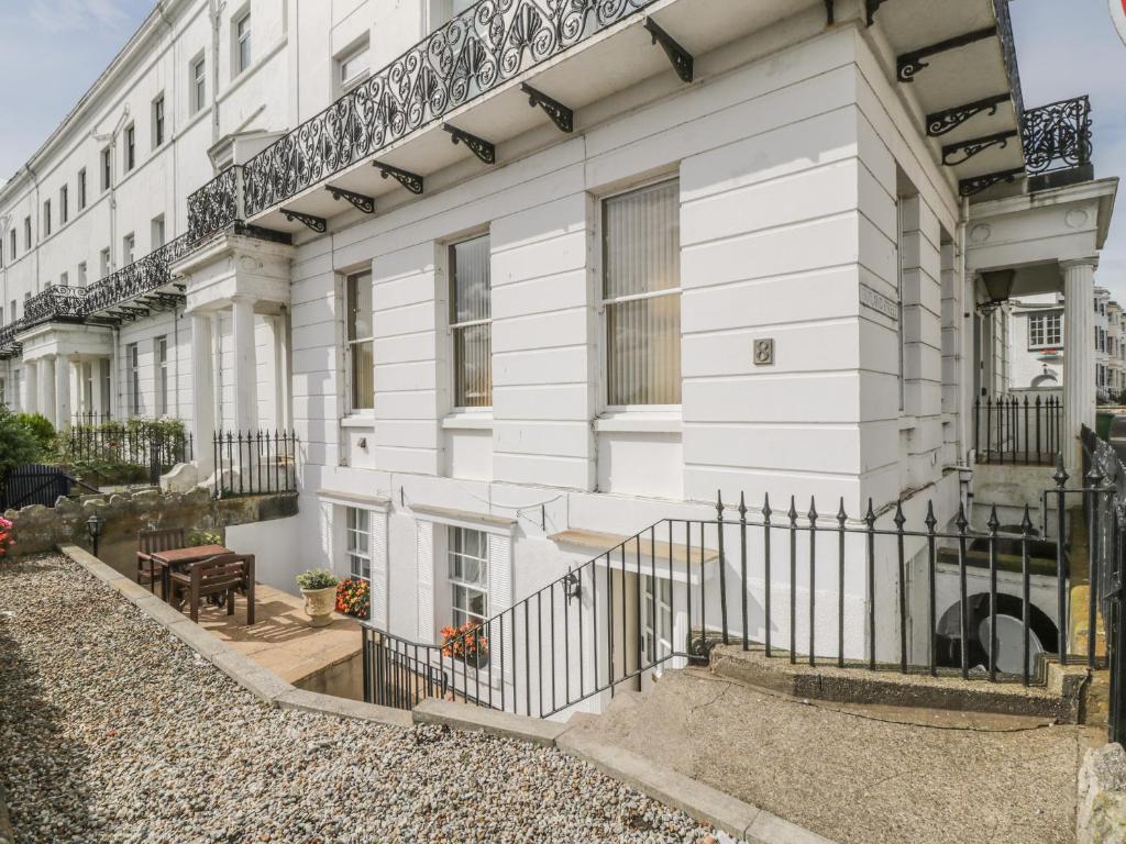 a white house with a fence in front of it at The Garden Apartment in Filey