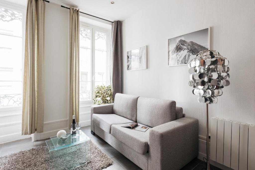 uma sala de estar com um sofá e uma cadeira em DIFY Glamour - Place des Brotteaux em Lyon